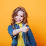 child with her thumbs up